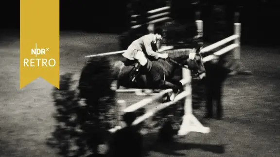 Springreiterin mit Pferd bei Bewältigung eines Hindernisses auf dem Parcours in der Ostseehalle Kiel 1961