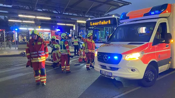 Rettungskräfte stehen am Lüneburger ZOB vor einem Bus und Rettungswagen.