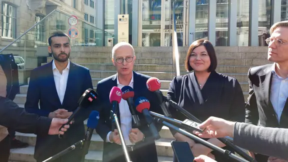 Peter Tschentscher (SPD), Katharina Fegebank (Grüne), Nils Weiland (SPD-Co-Landesvorsitzender) und Leon Alam (Co-Landesvorsitzender Grüne) stehen vor Mikrofonen.