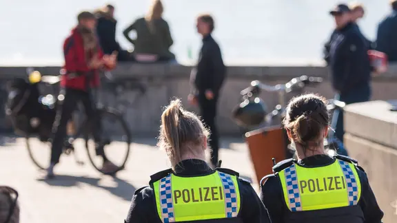 Zwei Polizistinnen kontrollieren am Zugang zum Elbstrand Övelgönne das in der Corona-Pandemie geltende Alkoholverbot.
