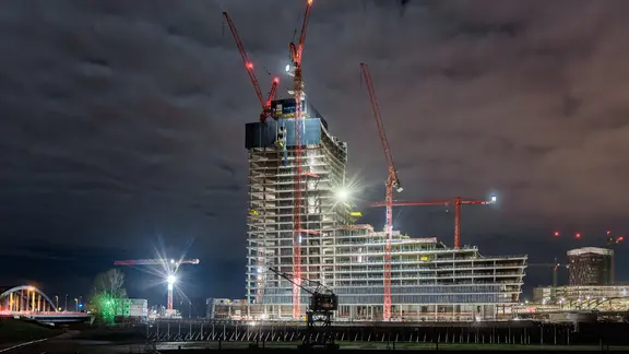 Der Elbtower-Rohbau leuchtet in der Nacht.
