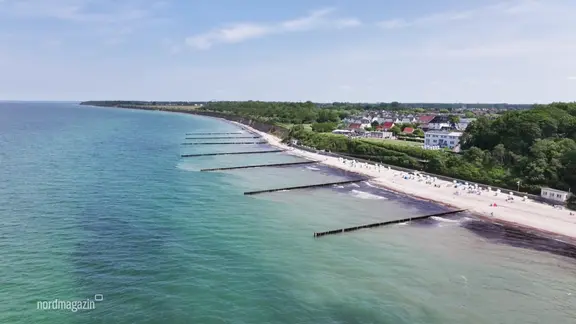 Blick aus der Luftperspektive auf einen Ostseestrand bei sommerlichem Wetter