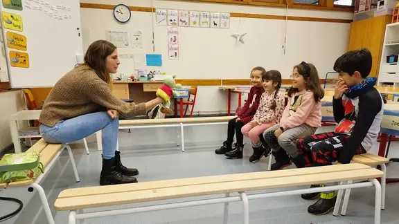 Eine Lehrerin unterrichtet Kinder mit einer Handpuppe.