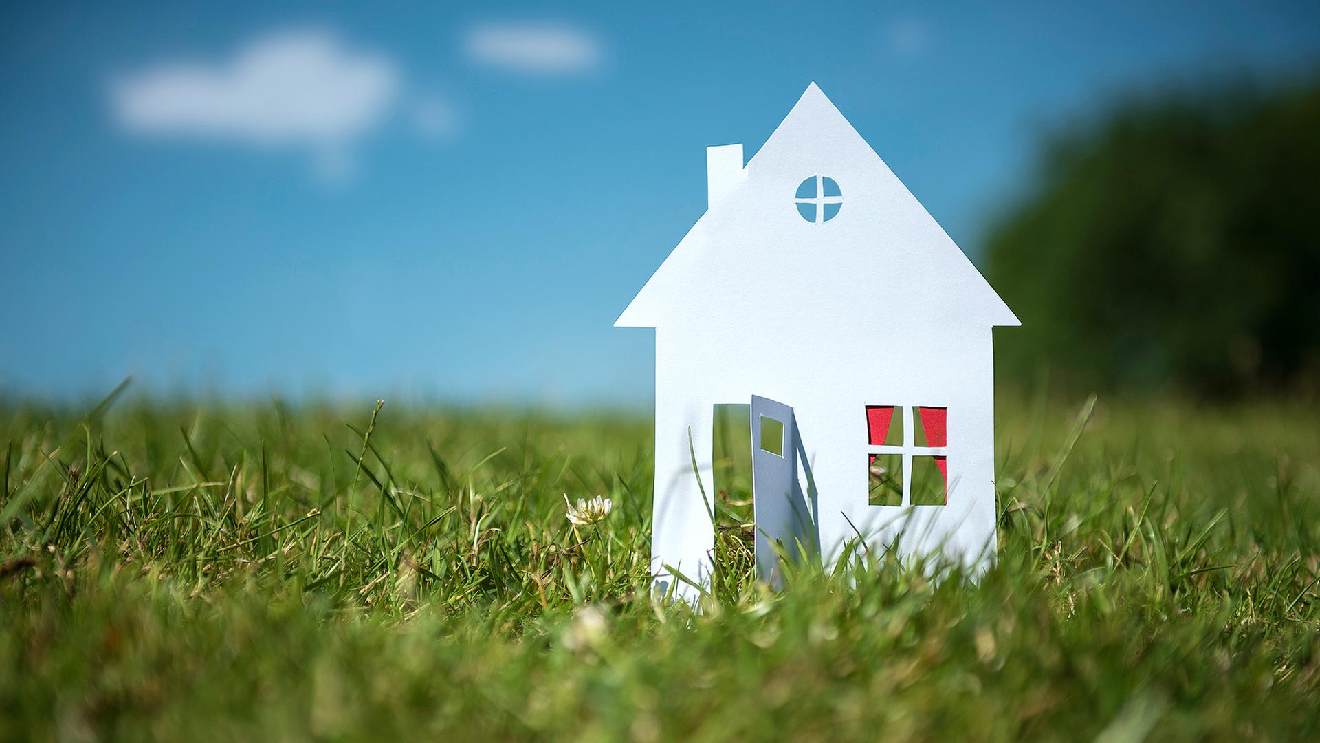 Papierhaus steht auf einer grünen Wiese | photocase, complize