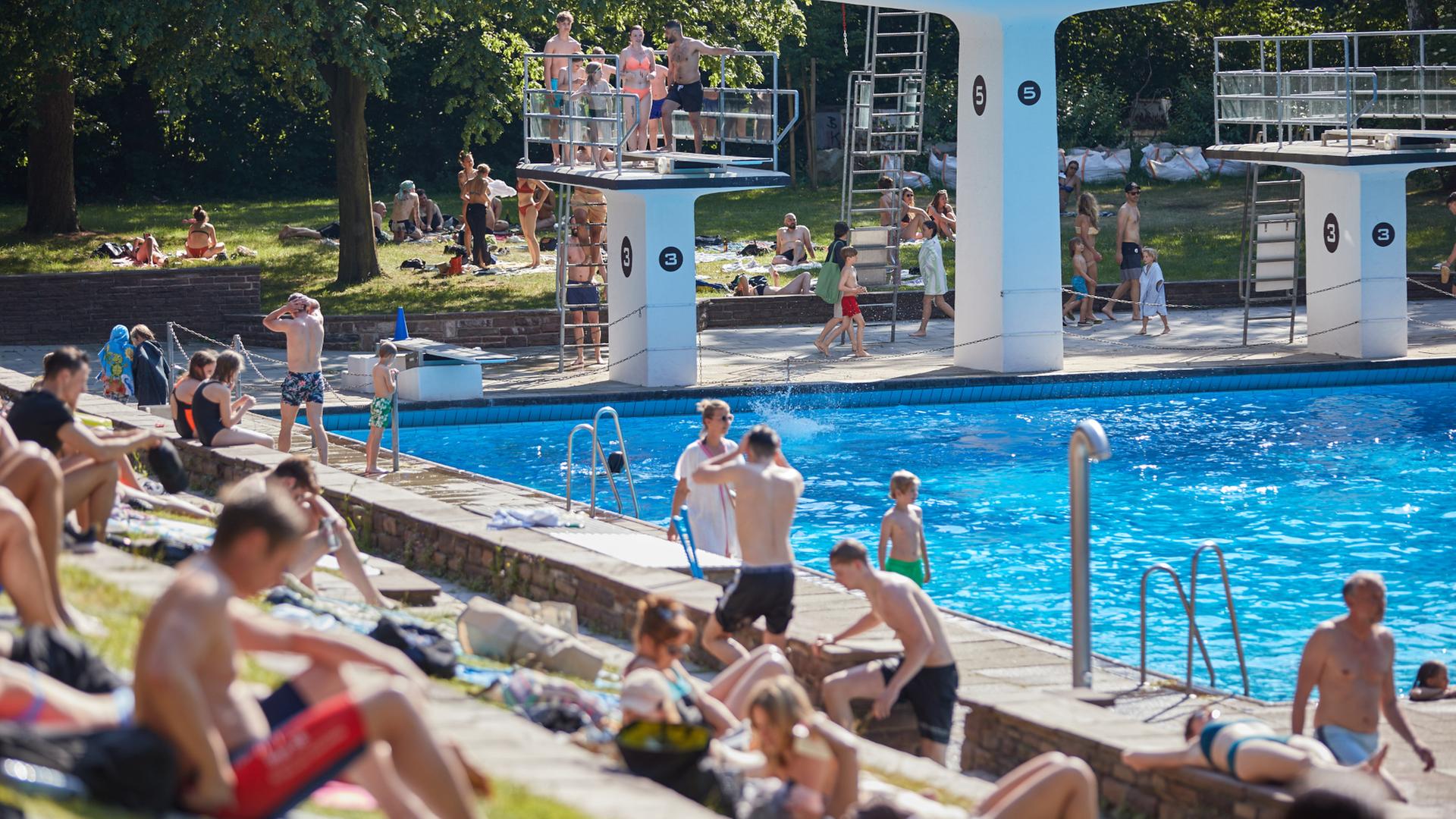 Besucher genießen im Sommerfreibad Kaifu-Bad in Hamburg die Sonne. | picture alliance/dpa | Georg Wendt