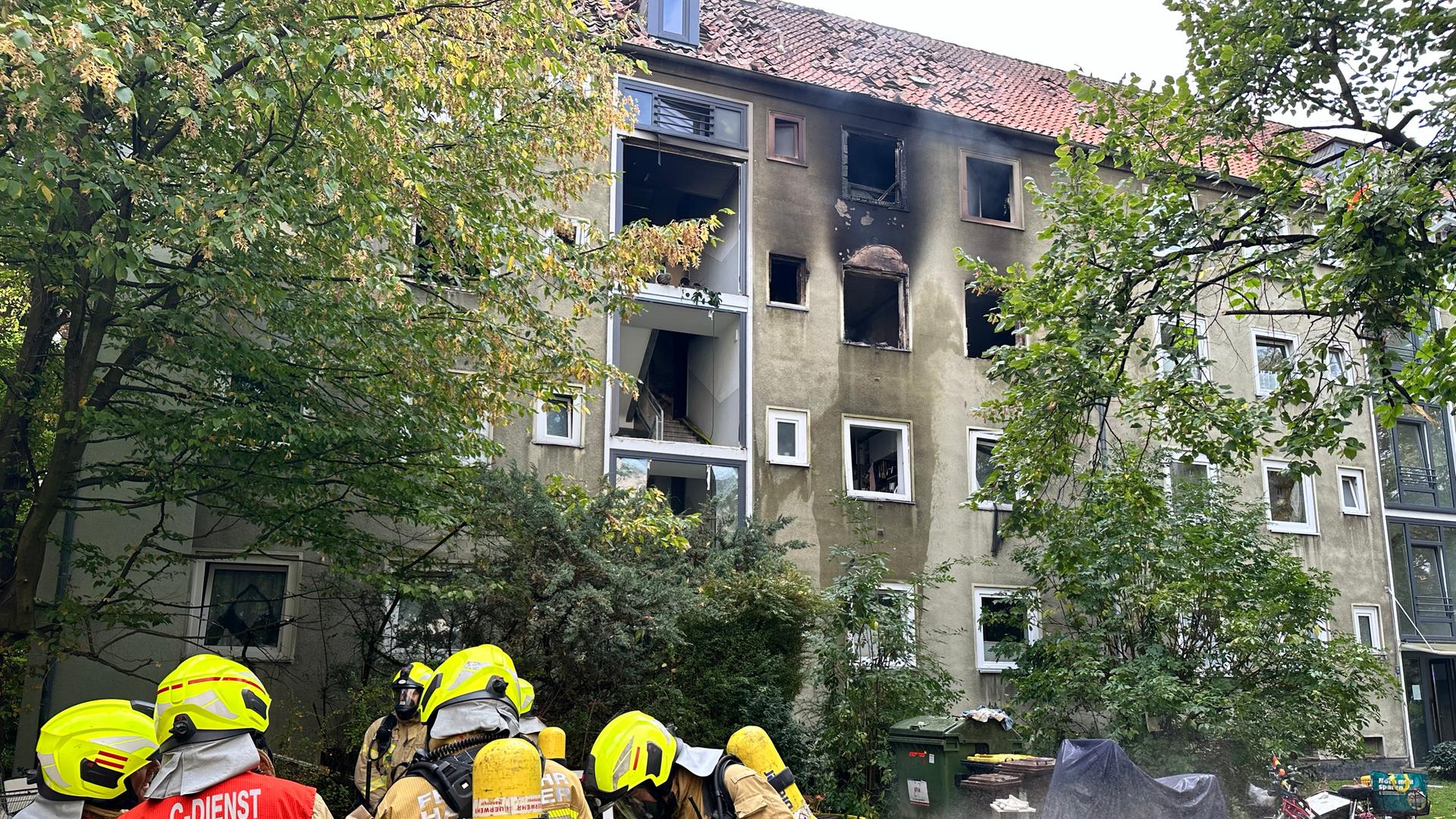 Feuerwehrleute stehen vor einem Mehrfamilienhaus nach einem Brand in Hannover-Ricklingen. | NDR / Kristina Hoffmann