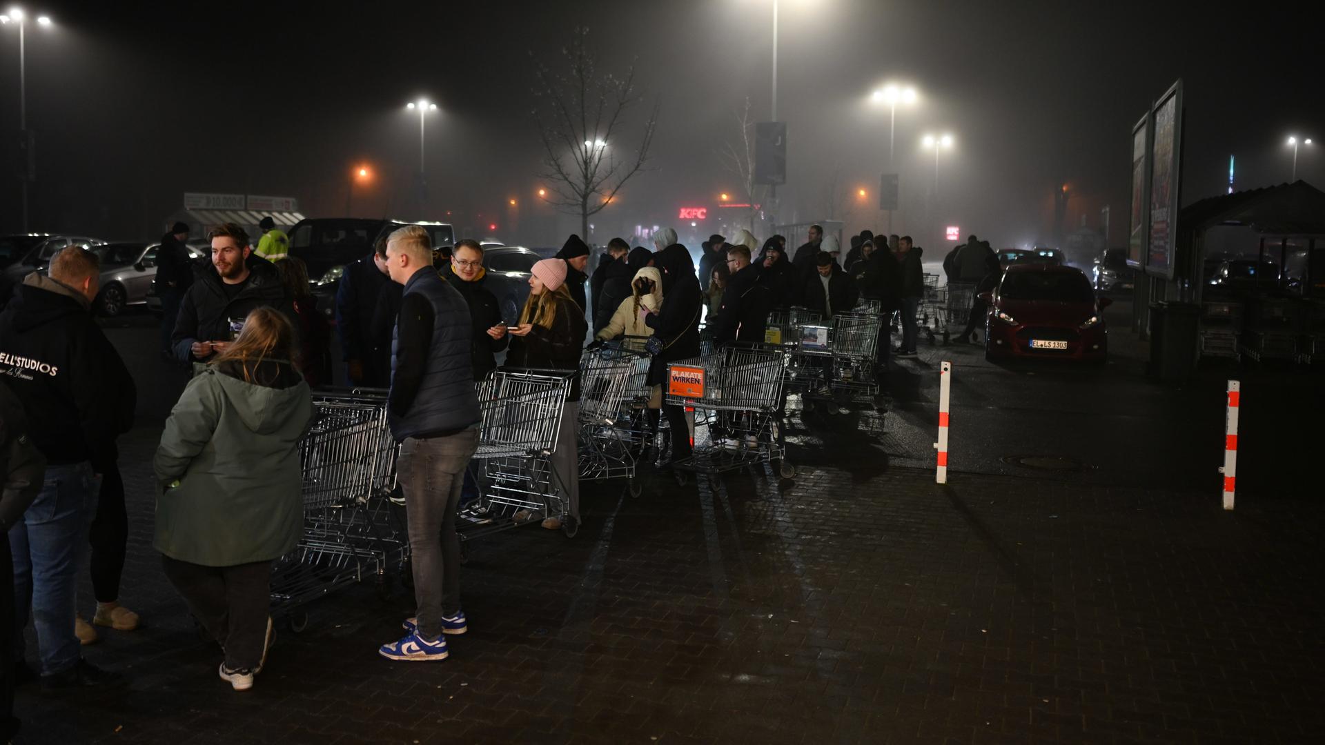 Zahlreiche Kunden warten in Meppen vor dem Geschäft auf den Verkaufsstart ab 0 Uhr. | Lars Penning/dpa +++ dpa-Bildfunk +++