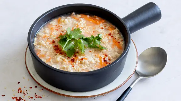 Ein kleiner Topf mit einer Hafer-Möhren-Suppe.