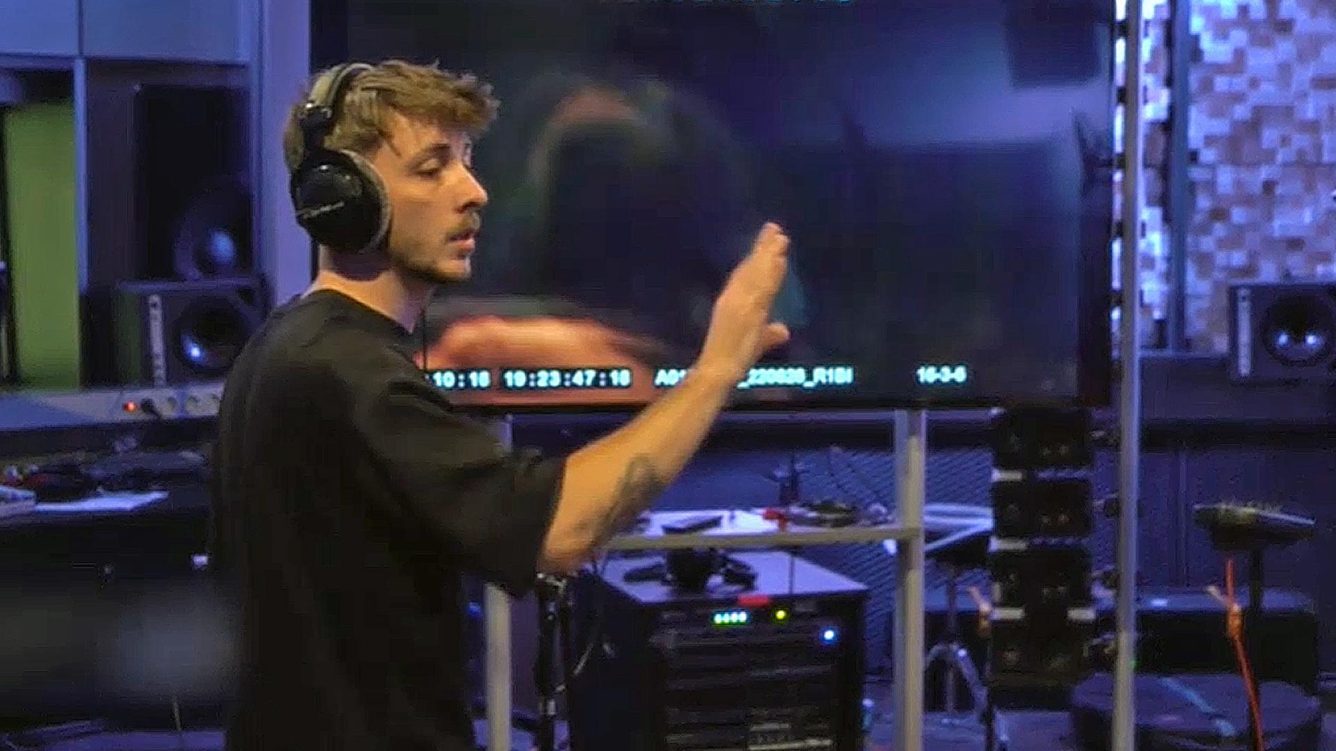 Ein Mann dirigiert vor einem Bildschirm | NDR.de