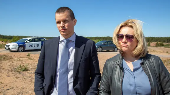 Man und Frau stehen am Strand und blicken in die Ferne