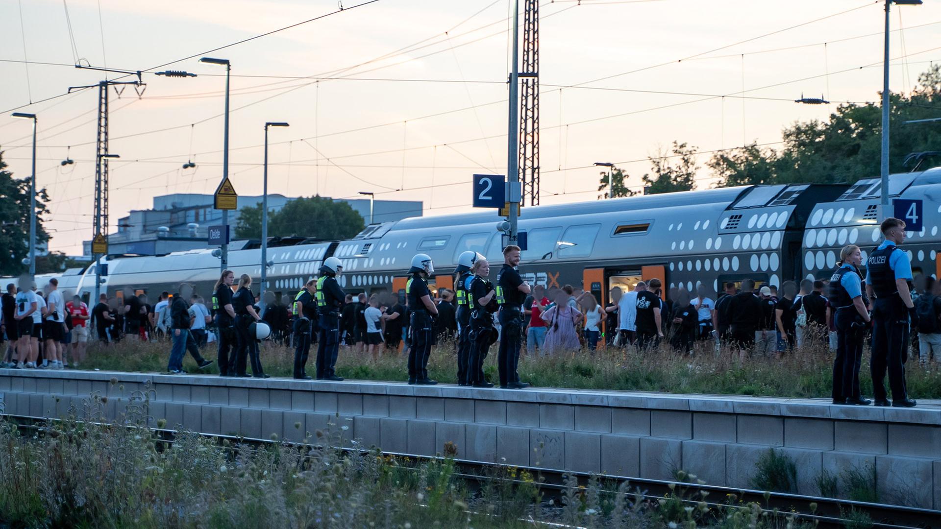 An einem Bahnsteig in Oelde stehen Polizeikräfte, zahlreiche Fahrgäste und eine Regionalbahn. | Max Lametz