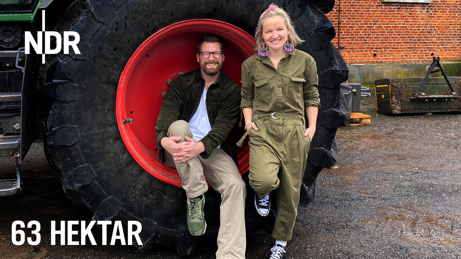 Landwirtin Maja Mogwitz und NDR Moderator Andreas Kuhlage sitzen in einem Treckereifen auf der Felge. | NDR, Jessica Schantin