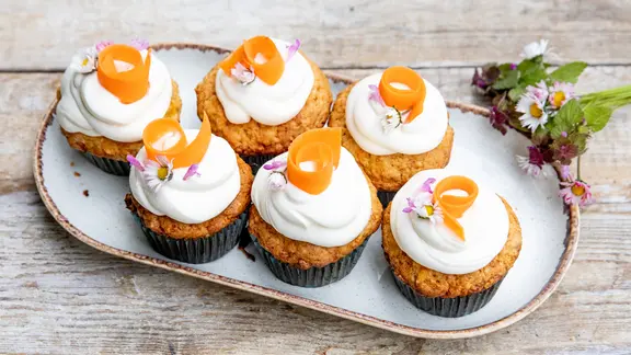 Möhren-Cupcakes mit Limetten-Frosting auf einer Platte serviert. | NDR, Claudia Timmann Möhren-Cupcakes mit Limetten-Frosting auf einer Platte serviert.