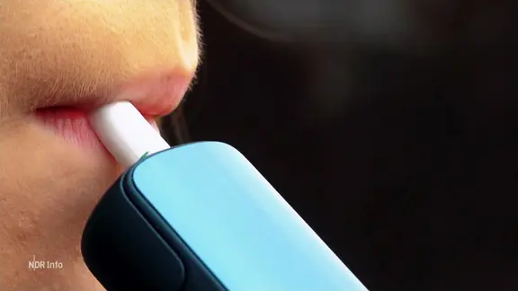Une jeune femme tire sur une cigarette électronique. | Capture d'écran Une jeune femme tire sur une cigarette électronique.