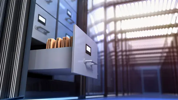 Eine offene Schublade mit Dateien in einem Archiv.