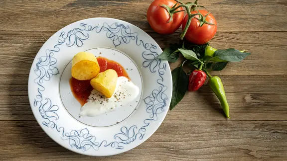 Pfannenkartoffeln mit roter und weißer Soße auf einem Teller serviert. | NDR, Frank von Wieding Pfannenkartoffeln mit roter und weißer Soße auf einem Teller serviert.