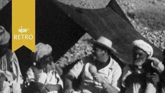 Reporter Hans Walter Berg 1959 mit afghanischen Nomaden vor deren Zelt.