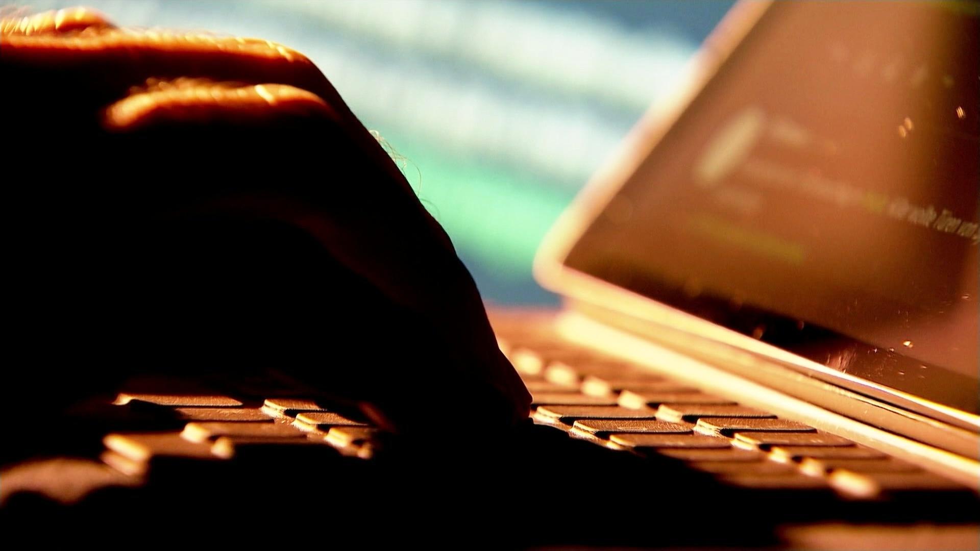 Eine Hand liegt auf einer Laptoptastatur. | Screenshot