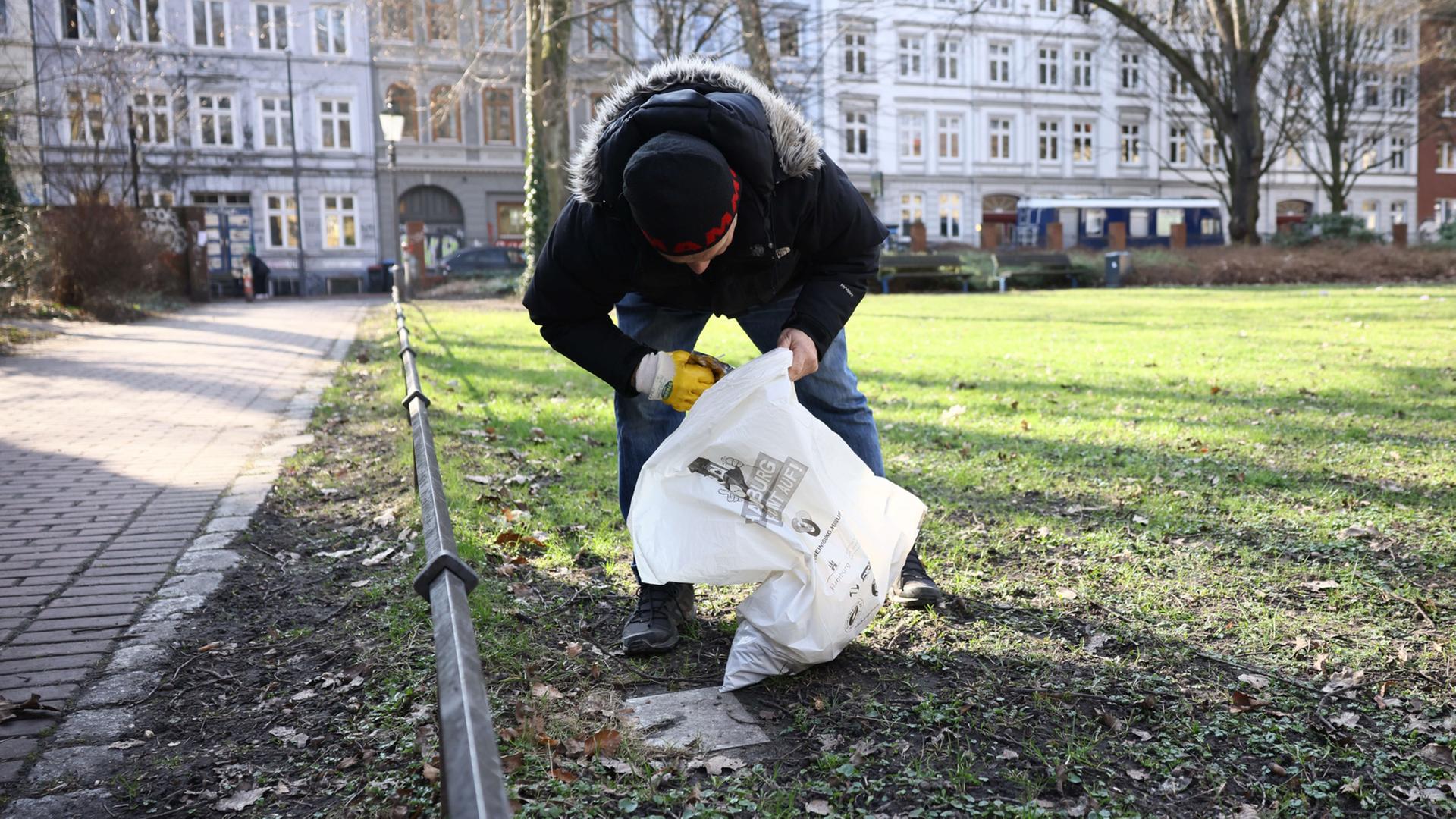 Mann bückt sich und sammelt Müll | Pressestelle Stadtreinigung Hamburg
