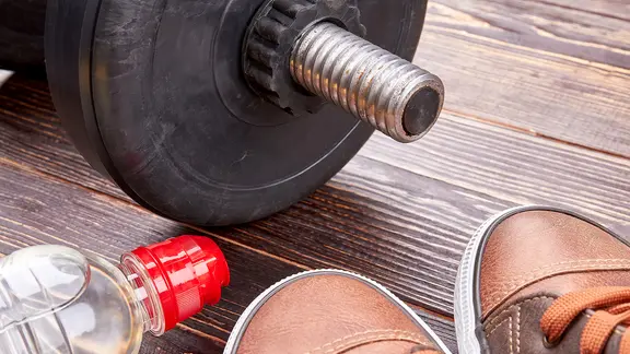 Hantel, Sneaker und eine Wasserflasche liegen auf dem Boden. | colourbox, - Hantel, Sneaker und eine Wasserflasche liegen auf dem Boden.