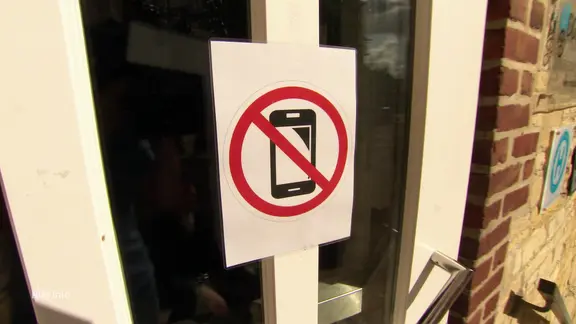 Ein Schild an einer Tür informiert über ein Handyverbot.