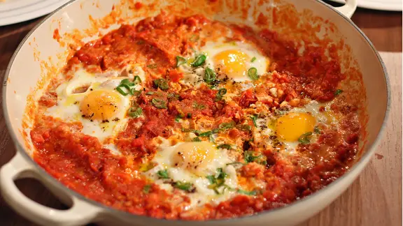 Die orientalische Tomaten-Paprika-Eierpfanne mit Namen Shakshuka in einer Pfanne serviert.