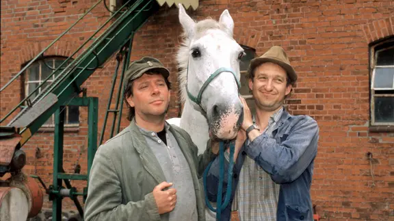 Szenenbild aus der 4. Büttenwarder-Folge "Liebesnacht": Brakelmann und Adsche stehen mit der rassigen Stute "Frau Meier" auf einem Hof.