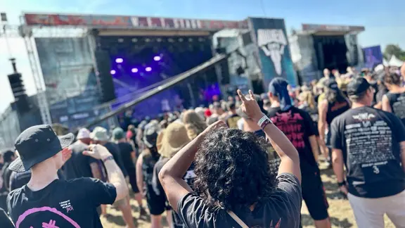 Fans stehen vor einer Bühne auf dem Wacken-Festival.