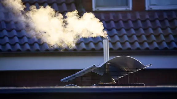 Rauchender Schornstein eines Hauses.