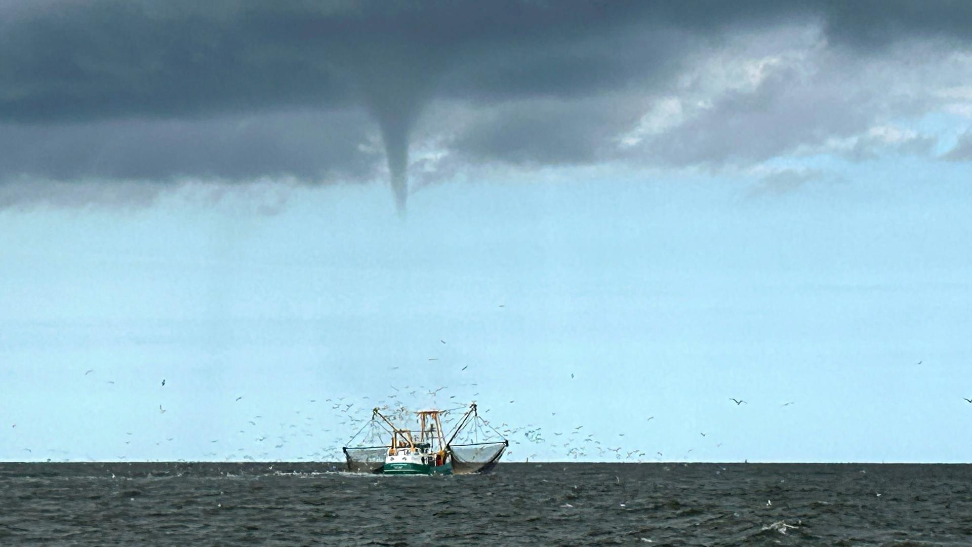 Auf der Nordsee vor Borkum entsteht ein Tornado. Im Vordergrund: Ein Fischerboot. | picture alliance/dpa-Bildfunk, Rolf Groenewold