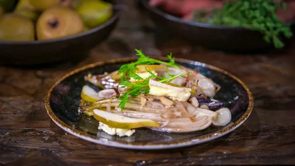 Ein Teller mit Ofen-Chicorée mit Blauschimmelkäse und Cashewkernen