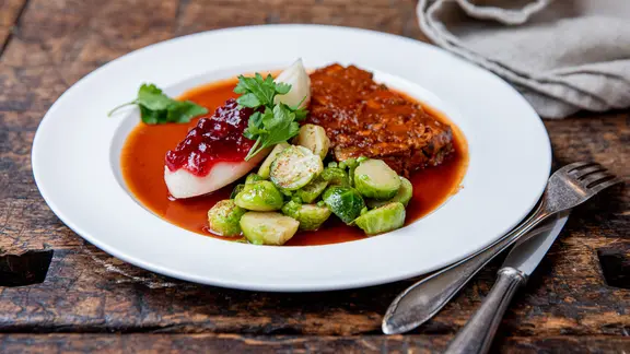 Ein Teller mit einem vegetarischen Nussbraten, Rosenkohl und Birnen.