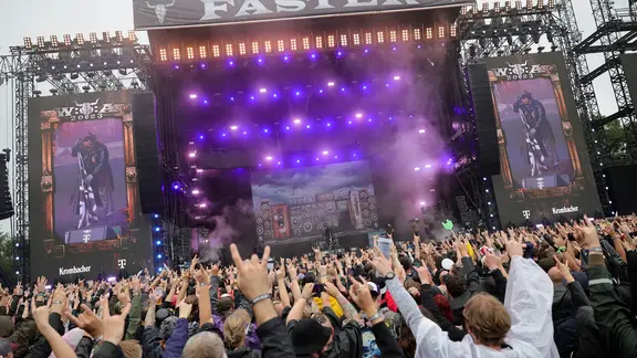 Fans recken vor der Bühne "Faster Stage" des Wacken Open Air 2023 ihre Finger hoch.