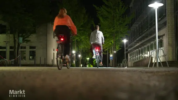 Zwei Fahrradfahrende bei Nacht.