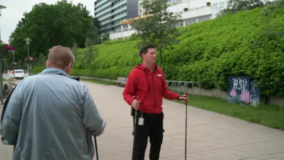 Menschen an der frischen Luft in Sportkleidung und mit Walking-Stöckern.