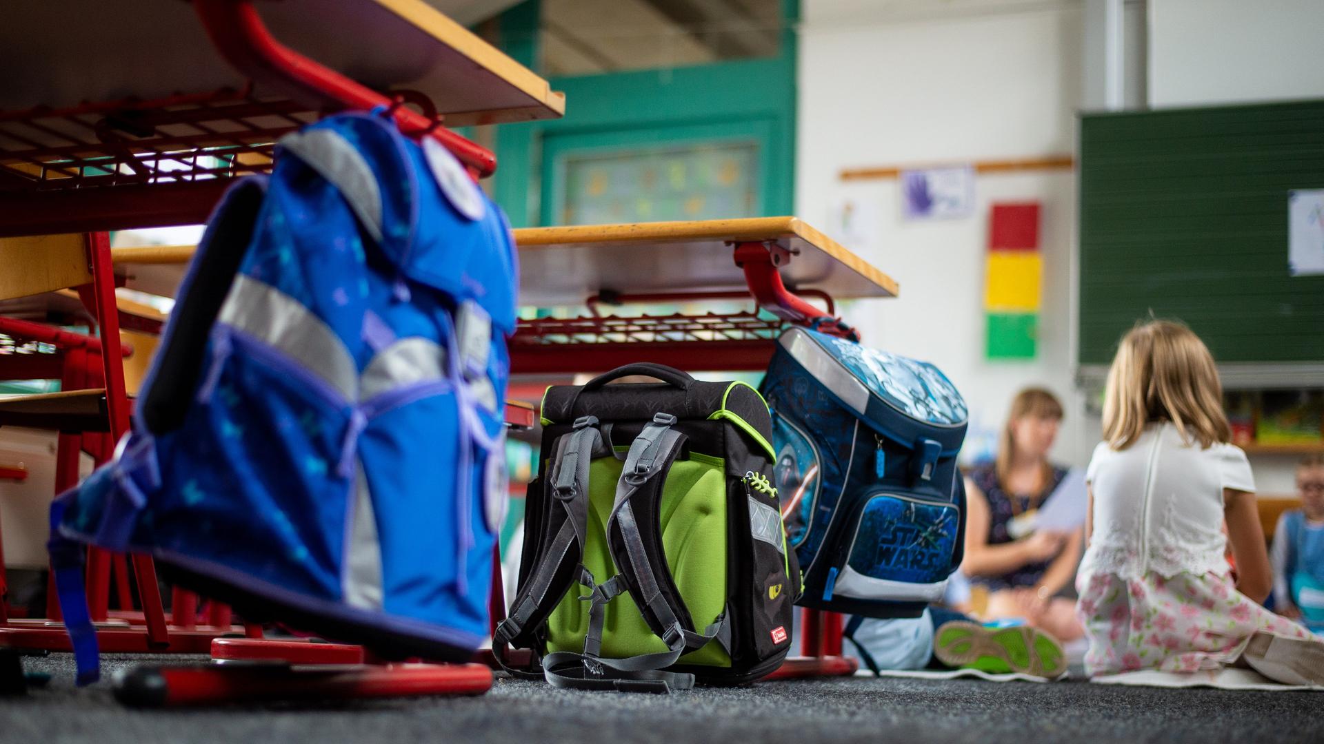 Grundschüler sitzen in ihrem Klassenraum im Kreis auf dem Boden. | picture alliance/dpa, Philipp Schulze