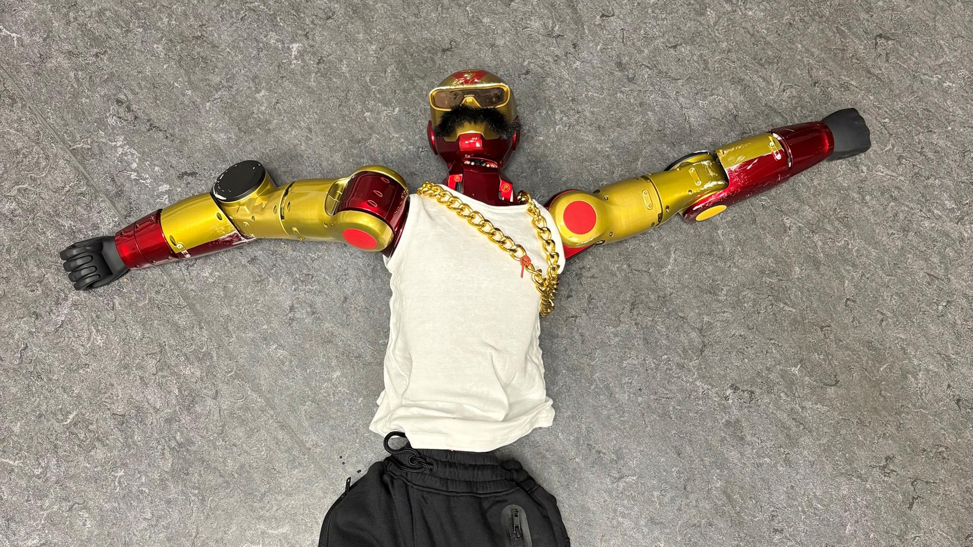Auf dem Boden liegt ein Roboter, der vom Aussehen her dem Comic-Held Ironman ähnelt. | Polizei Köln