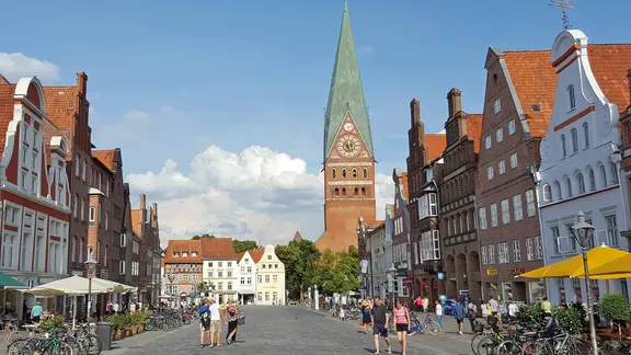 Die St.-Johannis-Kirche in Lüneburg, im Vordergrund histsorische Giebelhäuser am Sande | imago images/teutopress Die St.-Johannis-Kirche in Lüneburg, im Vordergrund histsorische Giebelhäuser am Sande