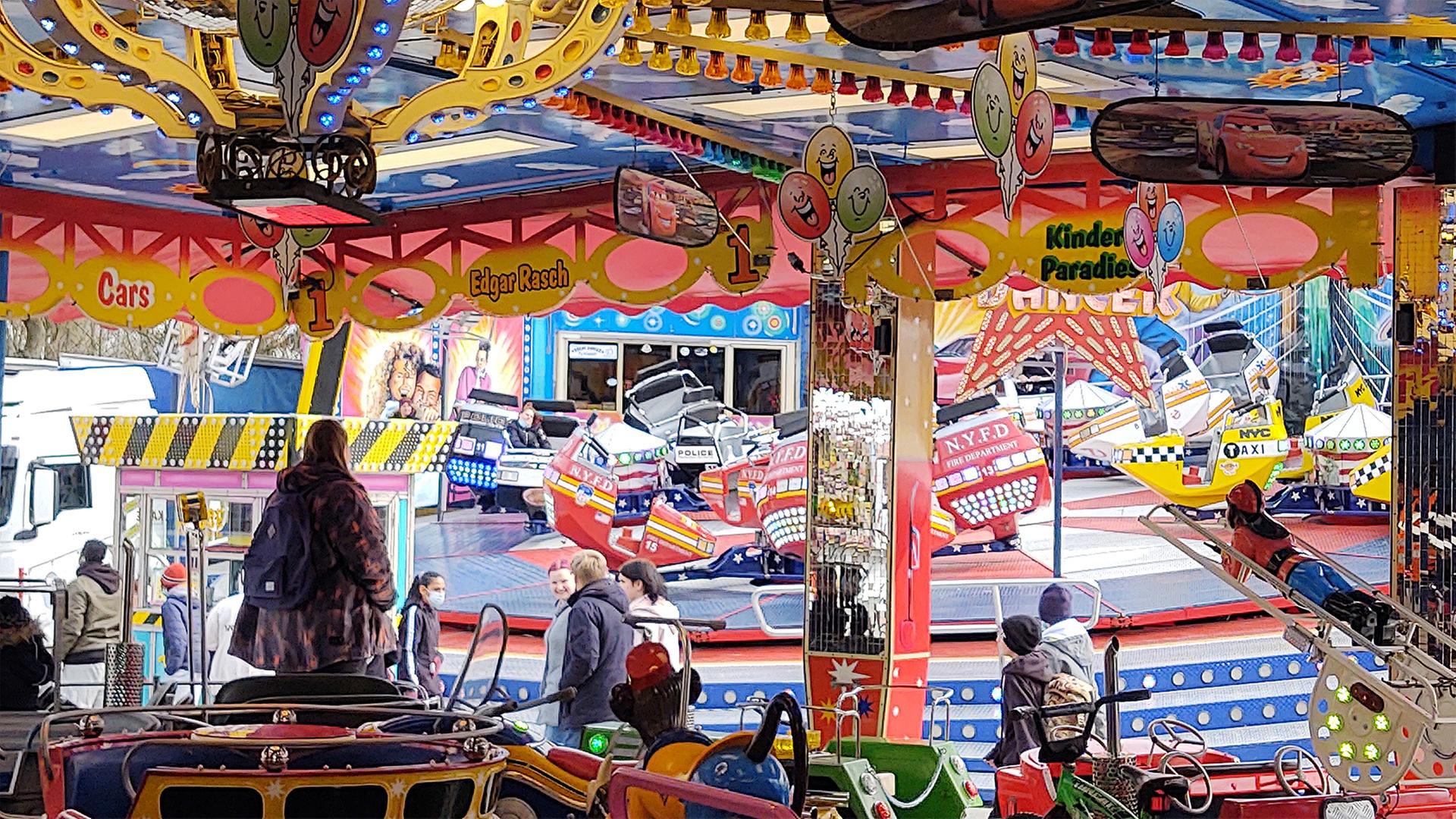 Fahrgeschäfte auf dem Jahrmarkt in Flensburg. Im Vordergrund ein Karussell, im Hintergrund der 
