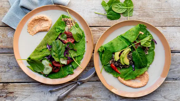 Pfannkuchen-Wraps mit Rohkost, Avocado und Quinoa auf einem Teller serviert