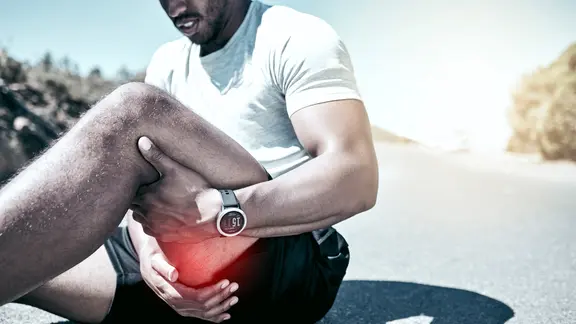 Muskelfaserriss: Mann in Sportkleidung fasst sich an den schmerzenden Oberschenkel.