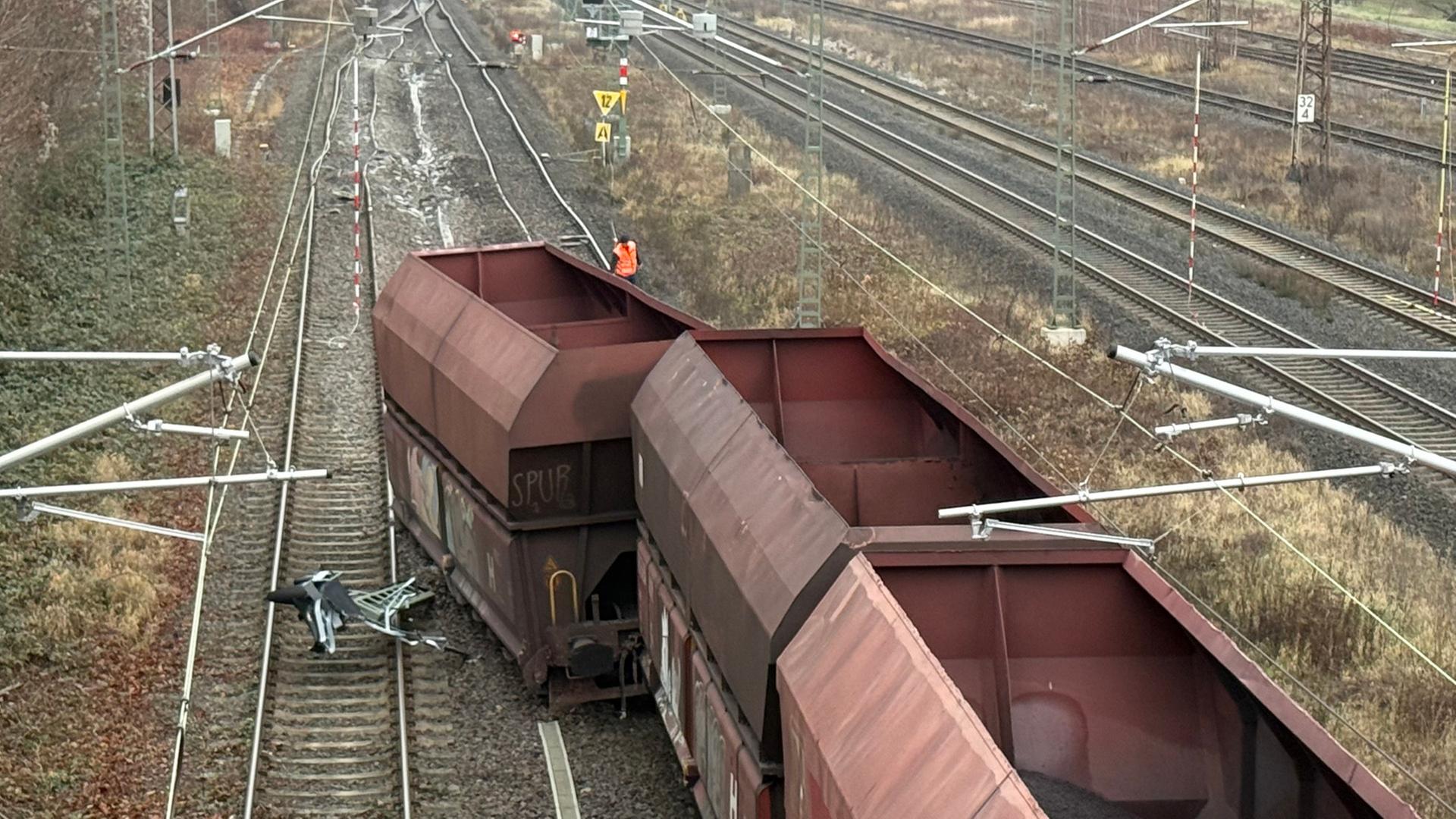 Ein Güterzug liegt auf Gleisen umgekippt auf der Seite neben einem umgekippten Mast. | HannoverReporter