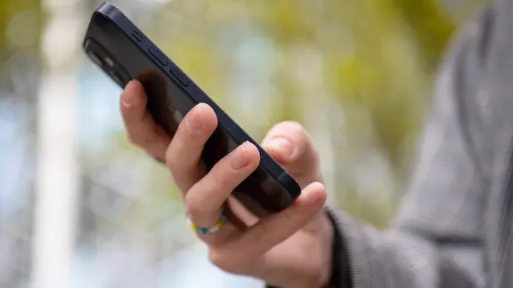Eine Person hält ein Smartphone in der Hand.