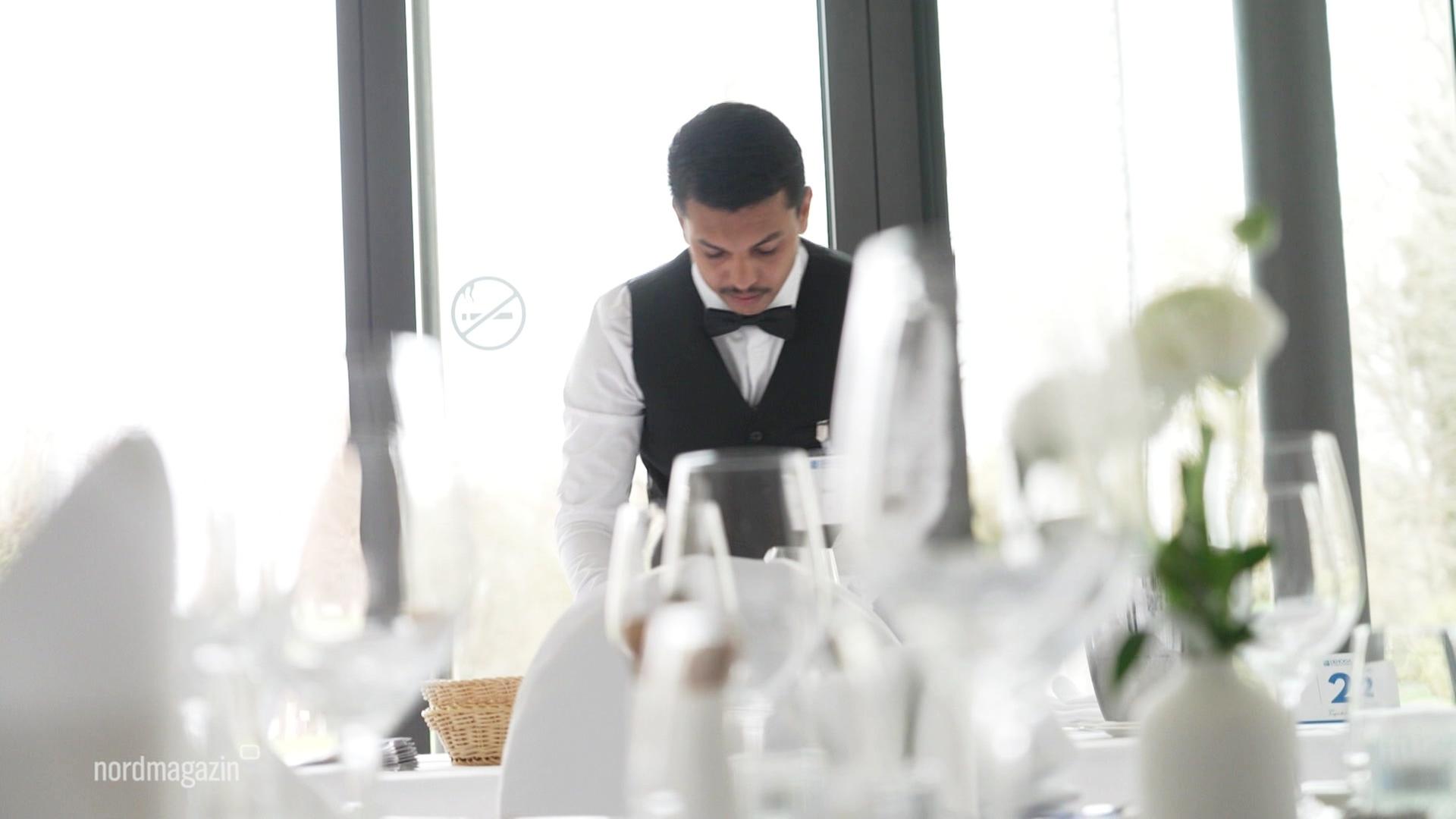 Ein Azubi deckt einen Tisch ein. | Screenshot