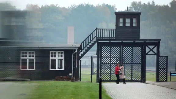 Besuchende gehen am Eingang des Stutthof Museums in Sztutowo (Polen) vorbei.