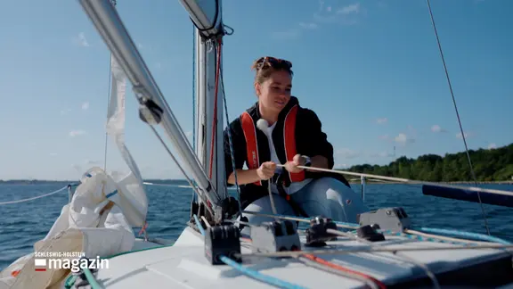 Auf einem Segelboot zeiht eine Frau an einem Seil