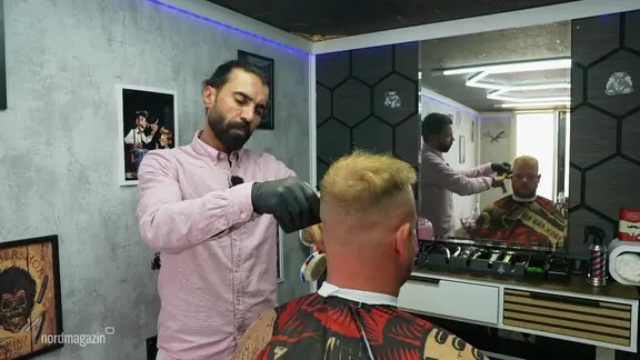 Fahed al Ramadan frisiert einen Kunden.