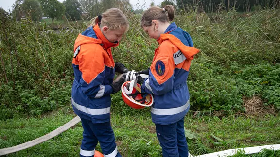 Mitglieder der Jugendfeuerwehr Wensin verbinden zwei Schläuche.