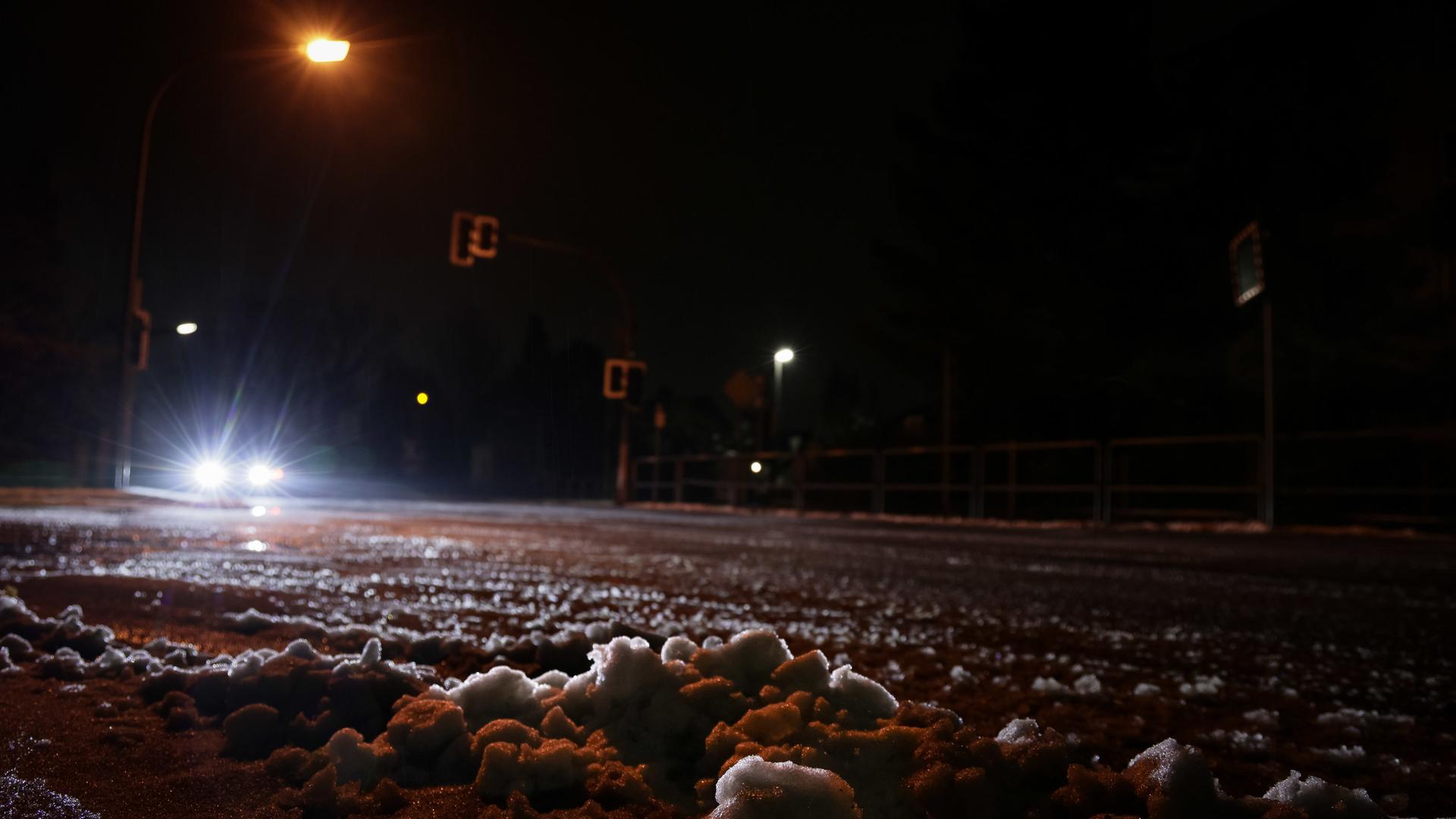 Ein Auto fährt bei Dunkelheit eine Straße entlang.  | picture alliance/dpa | David-Wolfgang Ebener