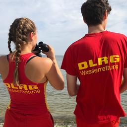 Ein Auszubildender und eine Rettungsschwimmerin am Strand von Cuxhaven.